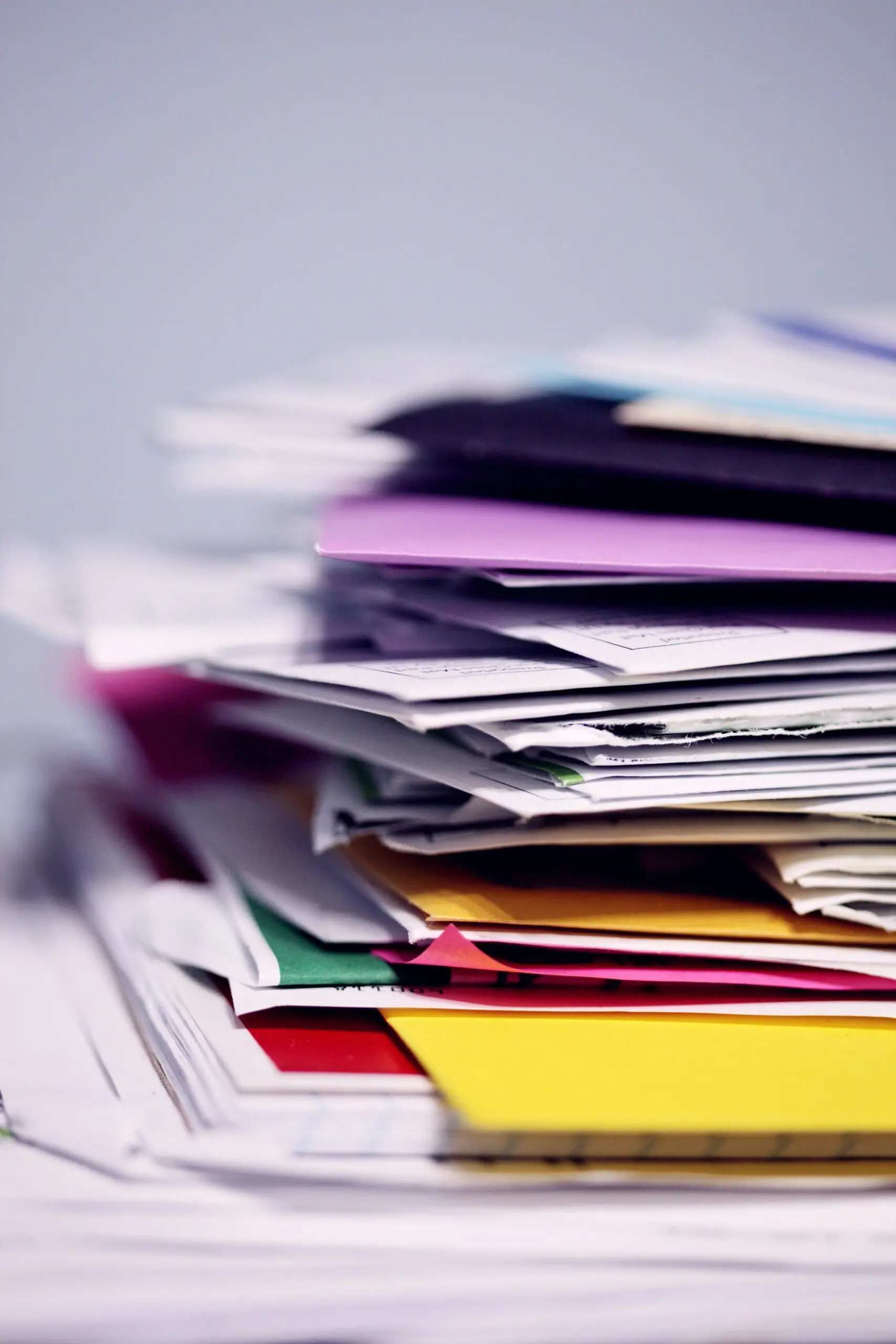 Piles of papers on a disorganized desk ready for bookkeeper to clean up the business's financials.