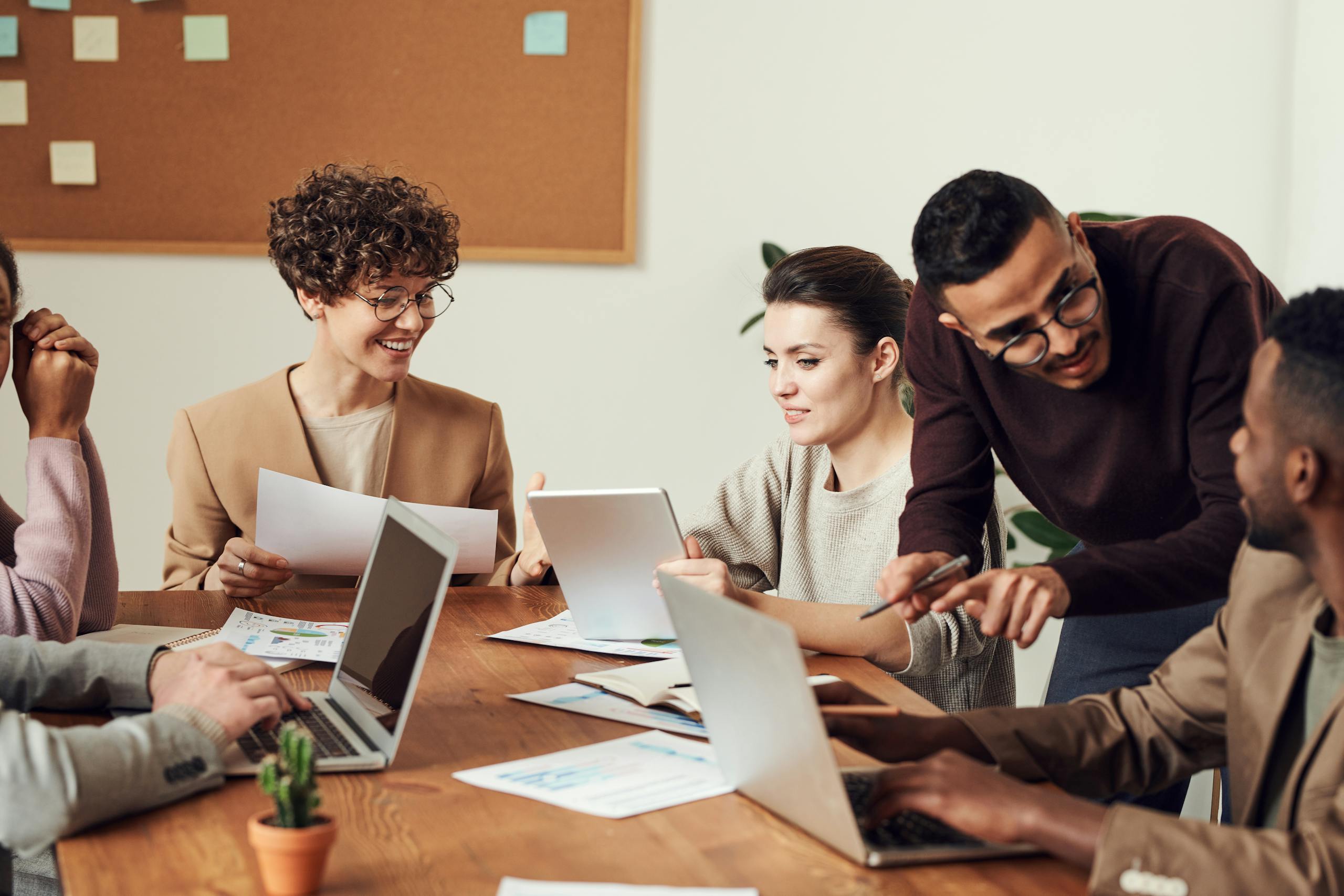 A diverse group of professionals engaged in a collaborative nonprofit office meeting, sharing ideas and discussing projects.