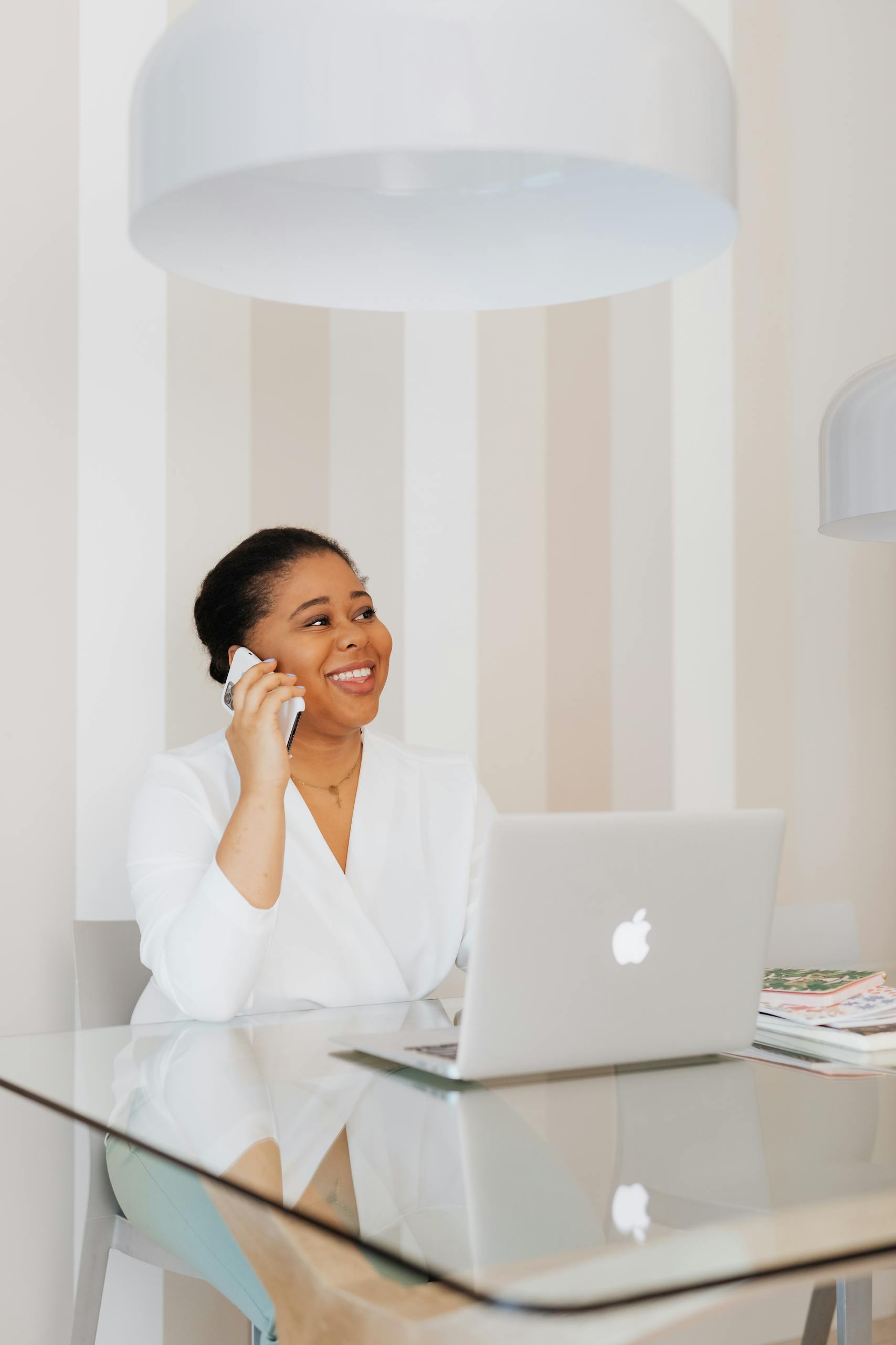 Professional female virtual bookkeeper in wheelchair working remotely on laptop and phone in a modern office.